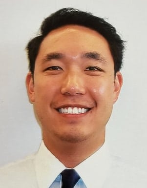 Headshot of ENT doctor smiling with beige background