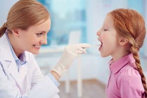 young girl getting her tonsil examed