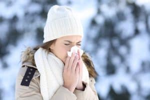 woman blowing nose in the snow